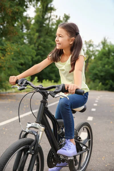 Little girl riding bicycle outdoors — Stock Photo, Image