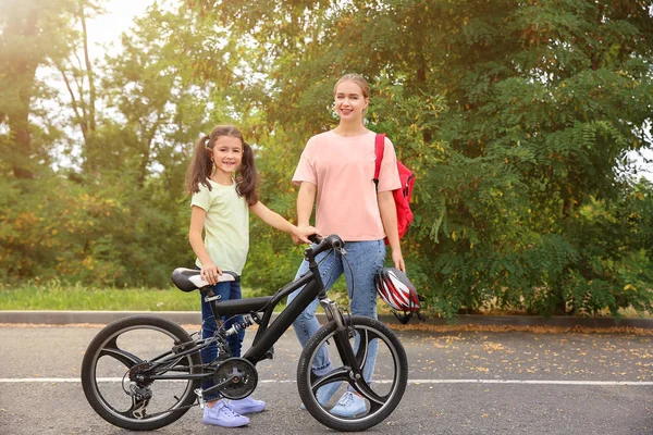 Woman and her little daughter with bicycle outdoors — Stock Photo, Image