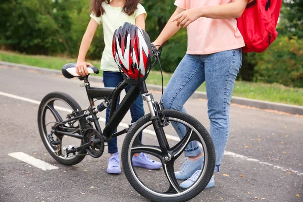 Woman and her little daughter with bicycle outdoors — Stock Photo, Image