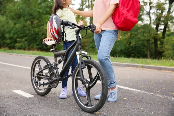 Жінка і її маленька дочка з велосипедом на відкритому повітрі — стокове фото