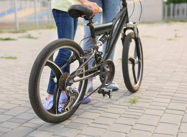 Mujer y su hijita con bicicleta al aire libre — Foto de Stock