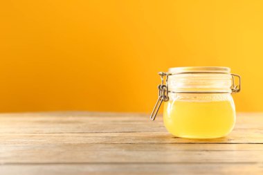 Renkli arka plan karşı ahşap masada lezzetli bal ile Kavanoz