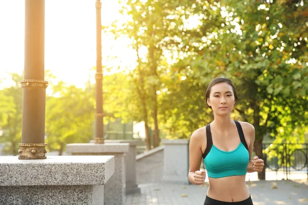 Sporty Asian woman running outdoors — Stock Photo, Image