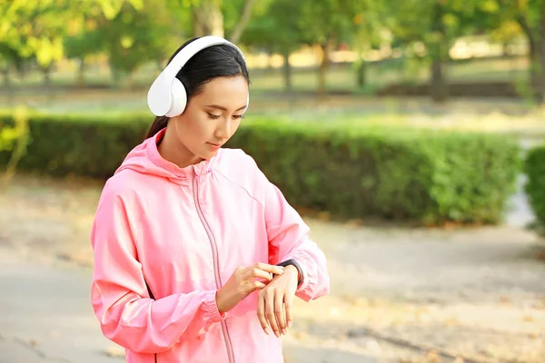 Sporty Asian woman with fitness tracker outdoors — Stock Photo, Image