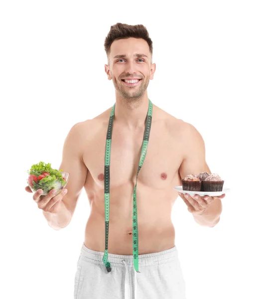 Hombre musculoso guapo con cinta métrica y comida sobre fondo blanco. Concepto de pérdida de peso —  Fotos de Stock