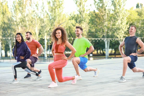 Fiatal, sportos emberek csoportja, akik együtt edznek a szabadban — Stock Fotó