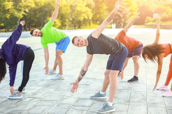 Group of young sporty people training together outdoors — Stock Photo, Image