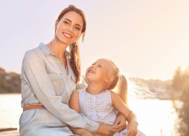Mutlu anne ve nehir kenarında onun küçük kızı