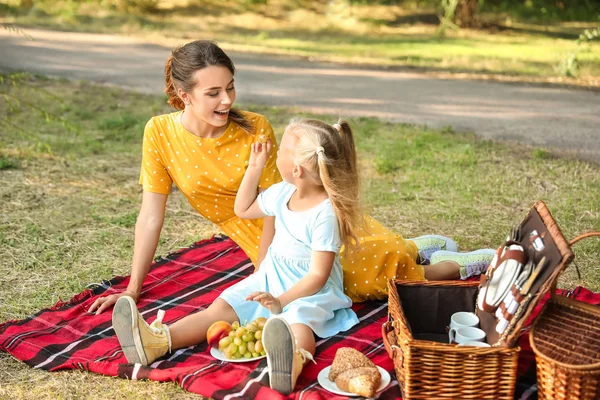 Mãe feliz e sua filhinha no piquenique no parque — Fotografia de Stock