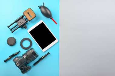Tablet bilgisayar ve renkli arka planda fotoğrafçının donanım seti
