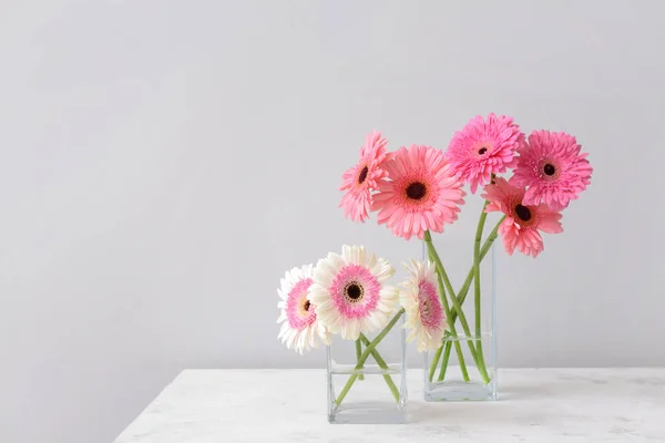 Vazen met mooie Gerbera bloemen op tafel — Stockfoto