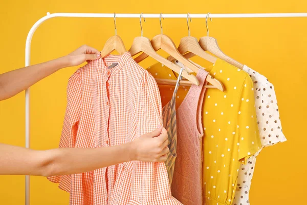 Kadın renk arka plan karşı rafta asılı giysi seçimi — Stok fotoğraf