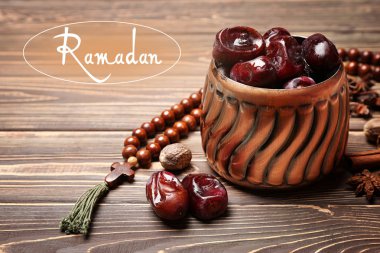 Ahşap masa üzerinde lezzetli tarihler ve boncuklar ile Vazo. Ramazan kutlaması