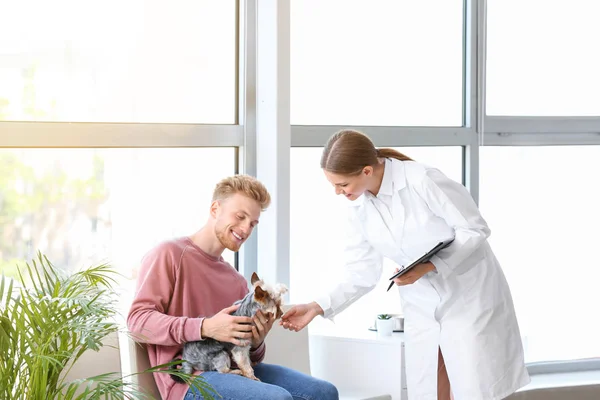 診療所で獣医を訪問する彼の犬を持つ男 — ストック写真