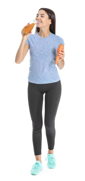 Молода жінка п'є морквяний сік на білому тлі — стокове фото