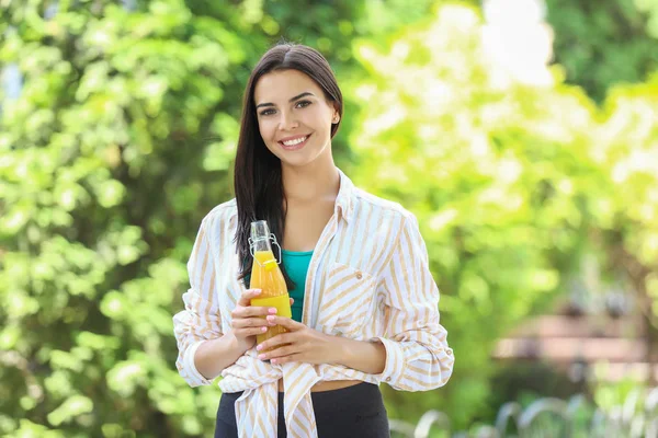 Young woman with healthy juice outdoors — Stock Photo, Image
