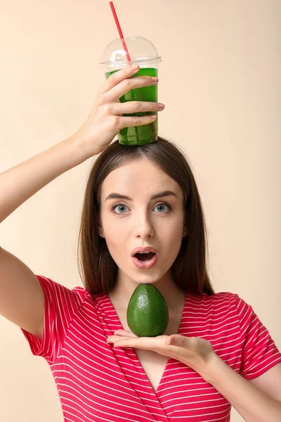 Mulher emocional com suco de legumes saudáveis e abacate no fundo claro — Fotografia de Stock