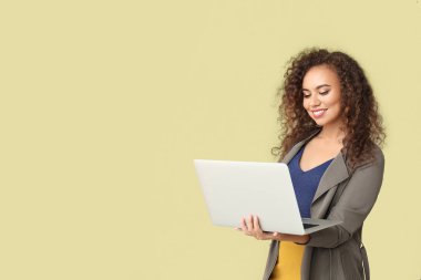 Renkli arka planda dizüstü bilgisayar ile şık Afrikalı-Amerikalı kadın