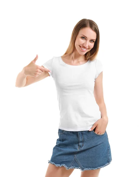 Frau zeigt auf ihr T-Shirt vor weißem Hintergrund — Stockfoto