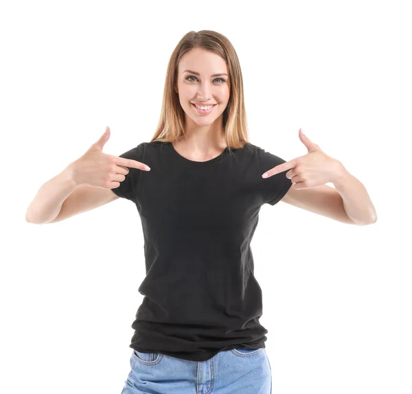 Frau zeigt auf ihr T-Shirt vor weißem Hintergrund — Stockfoto