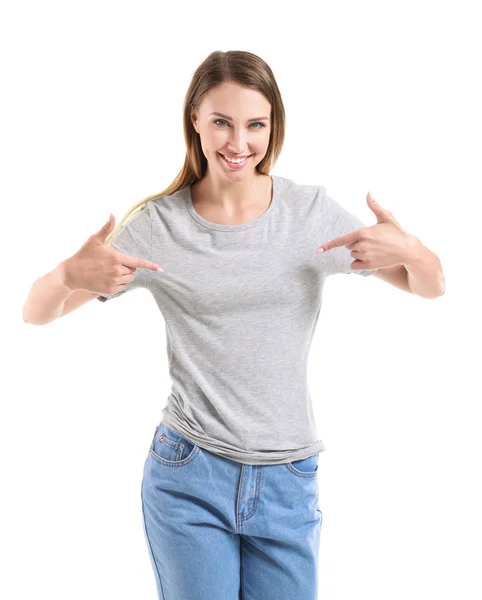 Vrouw wijst op haar t-shirt tegen witte achtergrond — Stockfoto