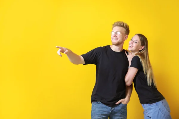 Couple in stylish t-shirts on color background — Stock Photo, Image