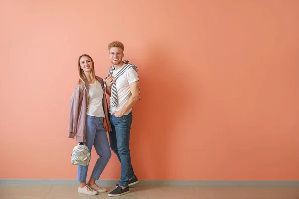 Couple in stylish t-shirts near color wall — Stock Photo, Image