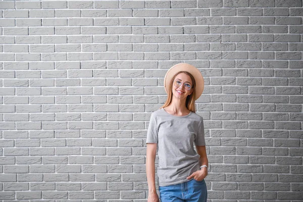 Mujer en elegante camiseta cerca de la pared de ladrillo —  Fotos de Stock