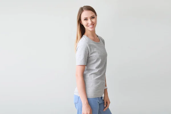 Frau im stylischen T-Shirt auf hellem Hintergrund — Stockfoto