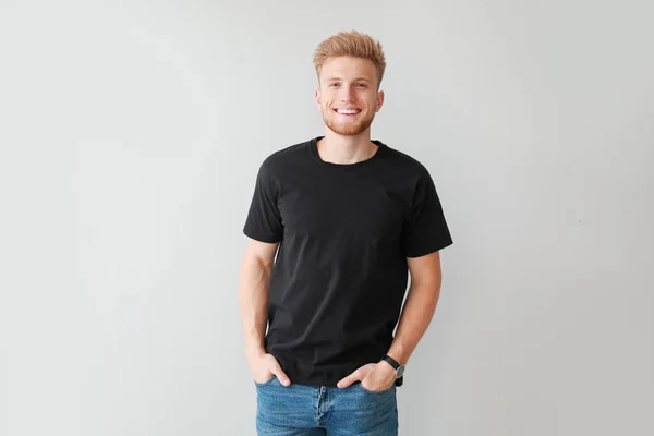 Mann im stylischen T-Shirt auf hellem Hintergrund — Stockfoto