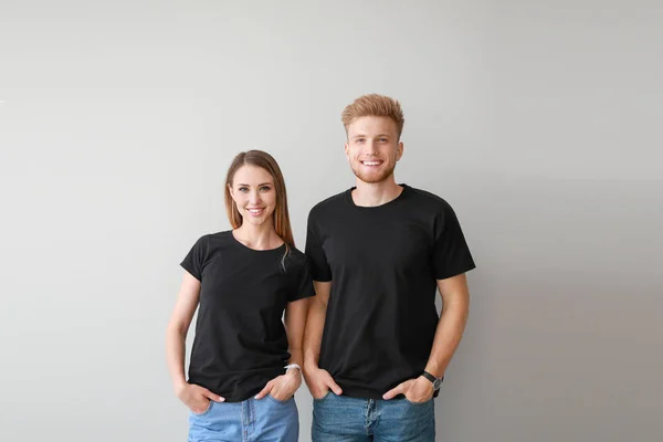 Couple in stylish t-shirts on light background — Stock Photo, Image