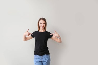 Kadın hafif arka plan karşı onu t-shirt işaret