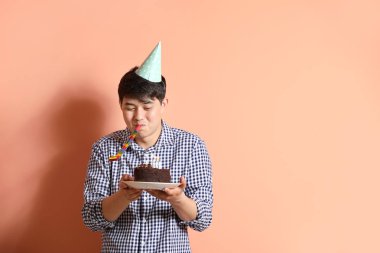 Renk arka planda parti düdük ve Doğum günü pastası ile Mutlu adam