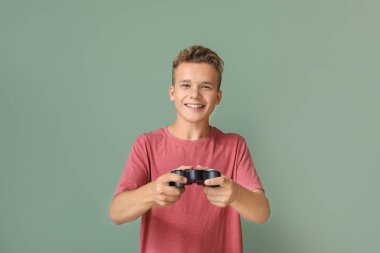 Genç çocuk renkli arka planda video oyunu oynuyor