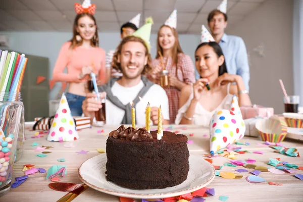 Tasty Birthday cake and group of friends at party