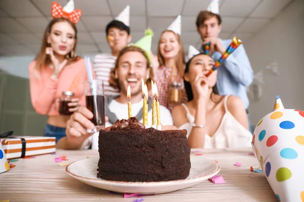 Смачний торт на день народження і група друзів на вечірці — стокове фото