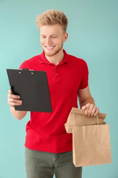 Handsome worker of food delivery service on color background — Stock Photo, Image