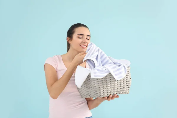 Beautiful young woman with laundry on color background — Stock Photo, Image