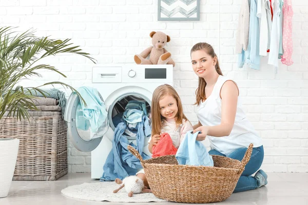Η γυναίκα και η κορούλα της κάνουν μπουγάδα στο σπίτι. — Φωτογραφία Αρχείου
