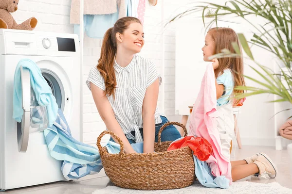 Mulher e sua filha fazendo lavanderia em casa — Fotografia de Stock
