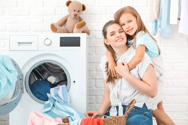 Mulher e sua filha fazendo lavanderia em casa — Fotografia de Stock