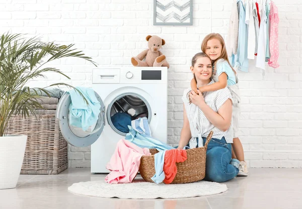 Mulher e sua filha fazendo lavanderia em casa — Fotografia de Stock