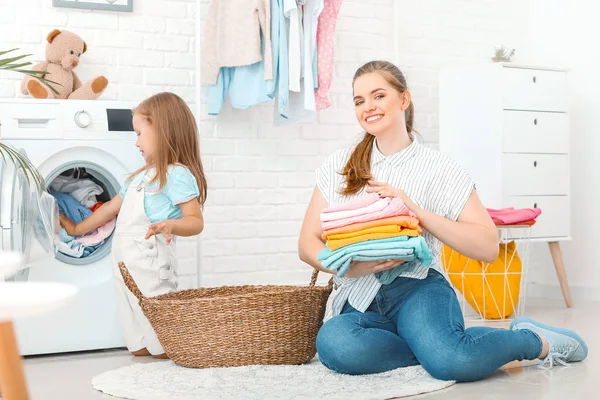 Mujer y su hijita lavando la ropa en casa — Foto de Stock