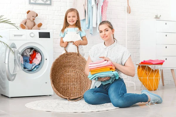 Mulher e sua filha fazendo lavanderia em casa — Fotografia de Stock