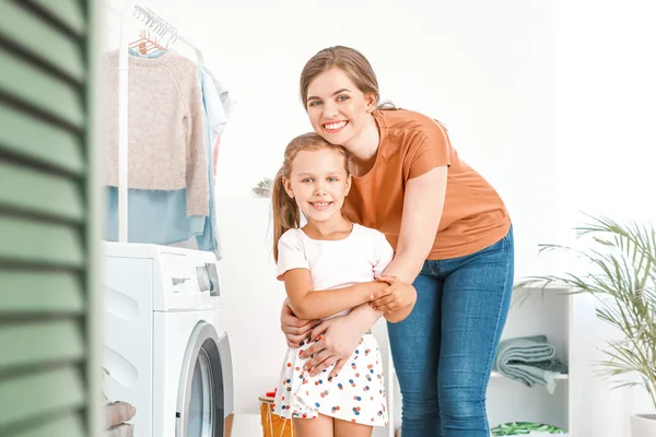 Mulher e sua filha fazendo lavanderia em casa — Fotografia de Stock