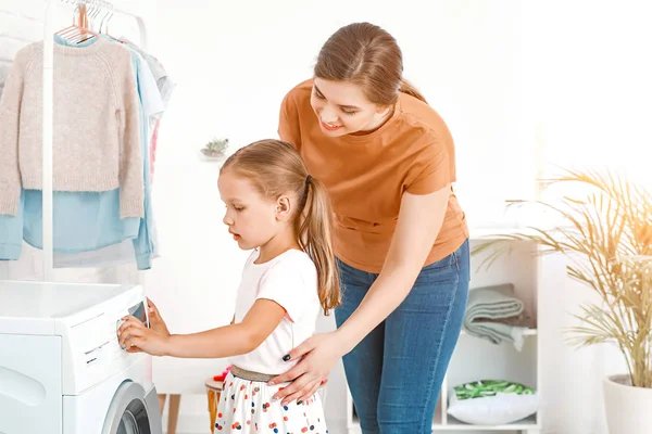 Mulher e sua filha fazendo lavanderia em casa — Fotografia de Stock