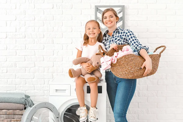 Woman and her little daughter doing laundry at home — Stock Photo, Image