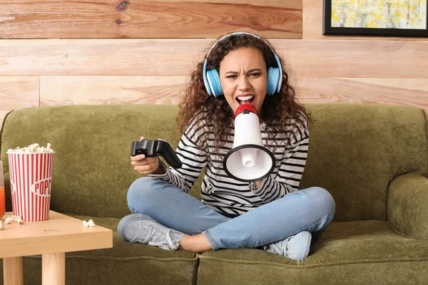 Adolescente afroamericana chica con megáfono jugando videojuego en casa —  Fotos de Stock