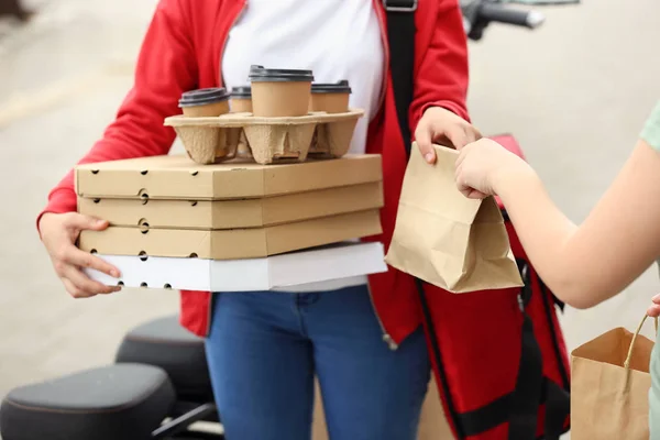 Woman taking order from courier of food delivery service outdoors — Stock Photo, Image