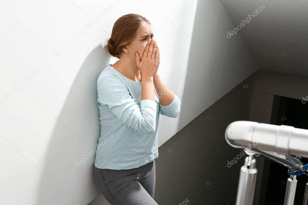 Woman having panic attack in the stairway